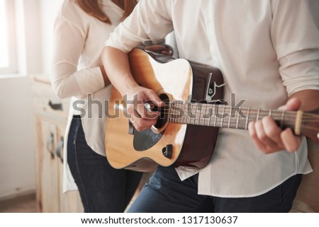 Beautiful instrument. Close up view. Guitarist playing love song for his girlfriend in the kitchen.
