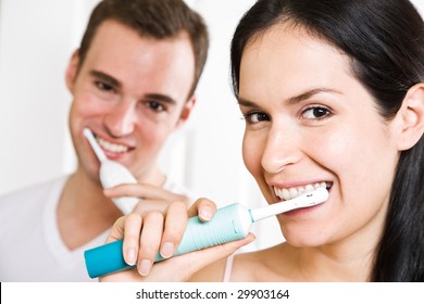 A beautiful interracial couple in the bathroom brushing teeth - Powered by Shutterstock