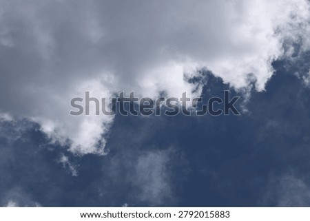 Beautiful iridescent clouds in a dramatic blue sky. Whispy white and grey clouds with subtle rainbow colors caused by light diffraction, creating a peaceful and spiritual atmosphere.