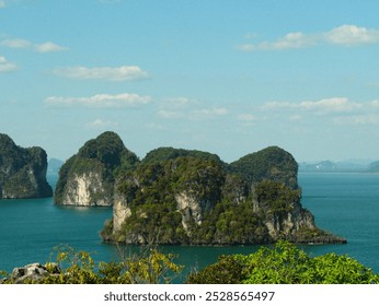 A beautiful island with a blue ocean in the background. The island is surrounded by water and has a rocky shoreline. The sky is clear and the sun is shining brightly - Powered by Shutterstock