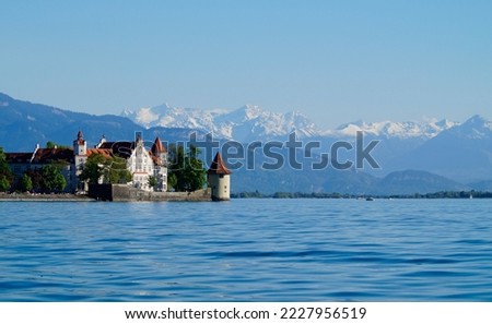 beautiful island of Lindau on lake Constance (lake Bodensee) with the snowy Swiss Alps in the background, Germany on fine sunny spring day                               