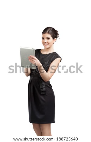 Beautiful isolated happy young woman in black dress using tablet computer.