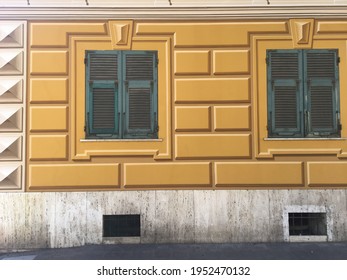 Beautiful Italian decorated facade, yellow tromp l'oeil green windows shutters