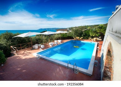 Beautiful Italian Villa With Pool And Deckchairs In Front Of The Sea