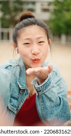 Beautiful Japanese Girl Sending Air Kiss While Recording Video For Her Blog On The Street. Pretty Asian Woman Making Content For Her Blog