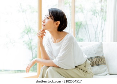 Beautiful Japanese woman thinking indoors
