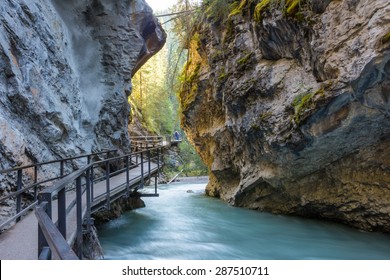 Beautiful Johnston Canyon walkway with turquoise water below, in Banff National Park, Alberta, Canada.  Shot with long exposure to give colorful river a smooth & dreamy effect.