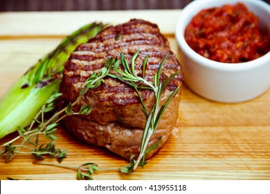 Beautiful juicy well done steak with sauce on a wooden Board