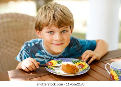 Beautiful Kid Boy Eating Apple Pie In Restaurant On Vacations. Happy Healthy Child In An Outdoor Cafe In Summer Time, Eating Cake