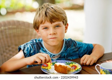 Beautiful Kid Boy Eating Apple Pie In Restaurant On Vacations. Happy Healthy Child In An Outdoor Cafe In Summer Time, Eating Cake