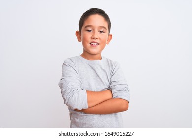 Beautiful kid boy wearing grey casual t-shirt standing over isolated white background happy face smiling with crossed arms looking at the camera. Positive person.