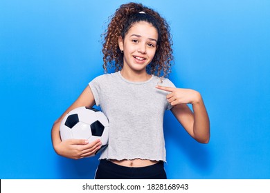 Beautiful Kid Girl With Curly Hair Holding Soccer Ball Pointing Finger To One Self Smiling Happy And Proud 