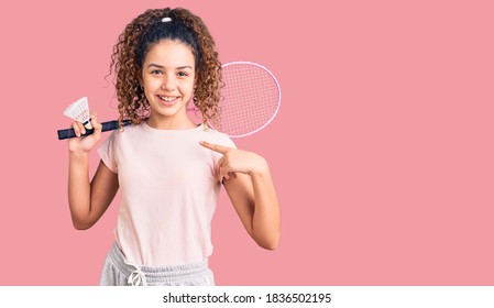 Beautiful Kid Girl With Curly Hair Holding Badminton Racket And Shuttlecock Pointing Finger To One Self Smiling Happy And Proud 