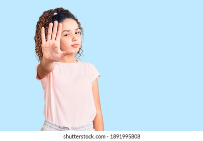 Beautiful Kid Girl With Curly Hair Wearing Casual Clothes Doing Stop Sing With Palm Of The Hand. Warning Expression With Negative And Serious Gesture On The Face. 