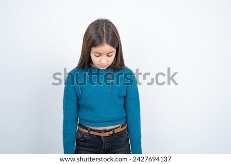 beautiful kid girl wearing blue t-shirt over white background looking sleepy and tired, exhausted for fatigue and hangover, lazy eyes in the morning.