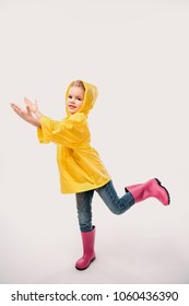 Beautiful Kid In Rubber Boots And Yellow Raincoat, Isolated On White