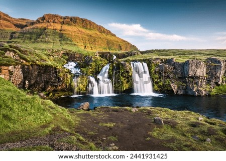 Beautiful Kirkjufellsfoss waterfall flowing from lush volcanic mountain in summer at Snaefellsnes peninsula, Iceland