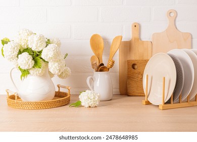 A beautiful kitchen backdrop with various kitchen utensils and a jug with flowering branches. still life. Front view. - Powered by Shutterstock