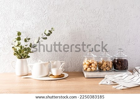 Beautiful kitchen background with items and products for the tea ceremony. glass jars with tea, sugar, biscuits and a white teapot and cups