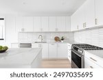 A beautiful kitchen detail with white cabinets, a gold faucet, white marble countertops, and a brown picket ceramic tile backsplash.