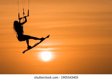 beautiful kitesurfing woman silhouette kiteboarder jumping sport at sunset golden hour, kite surfing girl kiteboarding jump - Powered by Shutterstock