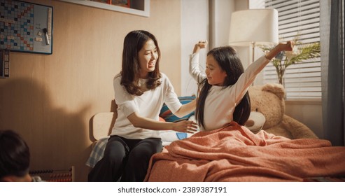 Beautiful Korean Mother Enters Children's Room. Little Son is Playing with Toys, Daughter is Waking Up, Stretching Her Arms in a Cute Way. Lovely Asian Family Ready to Spend Sunny Day Together - Powered by Shutterstock