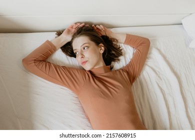 The Beautiful L Top Shot Of A Female Model With Brown Hair Posing On A White Bed In The Bedroom