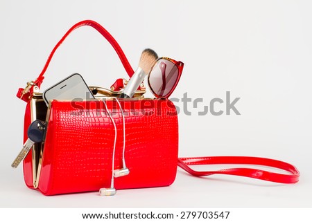 Beautiful lacquered red bag with women's accessories.