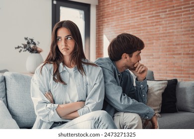 Beautiful lady is depressed, sitting on the couch talking to man, having a dispute with husband or boyfriend, looking desperate and hopeless, having unresolved problem or question - Powered by Shutterstock