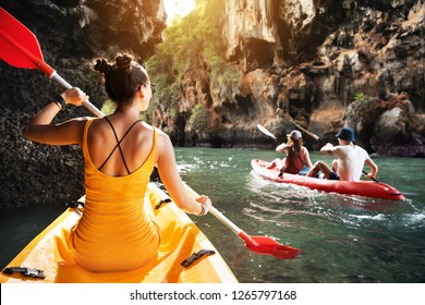 Beautiful Lady And Friends Walks By Kayaks At Sea Bay Between Big Rocks