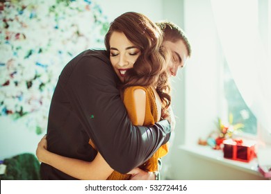 Beautiful lady leans to man's shoulder while he hugs her