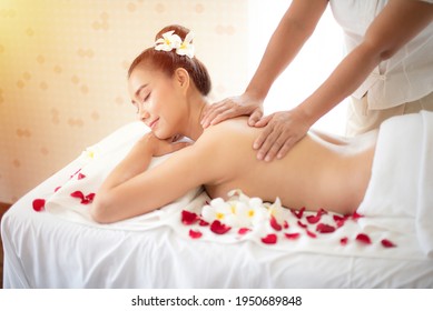 Beautiful lady lying on a massage table, smiley face while doing a shoulder massage from a professional masseuse in spa. She feeling very happy, so relax and rest.