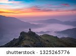 Beautiful Lake District sunrise from a summit over misty valley of Grasmere