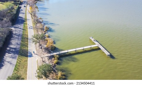 Beautiful lakeside park with long jetty boardwalk fishing dock and fishermen near Dallas, Texas, America. Aerial view outdoor and recreational activities in fall afternoon at urban park