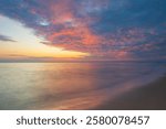 Beautiful  landsape  with  dramatic  golden  sky  over  the  sea  and  reflection  at sunset  time in  the summer,long  time  exposure.