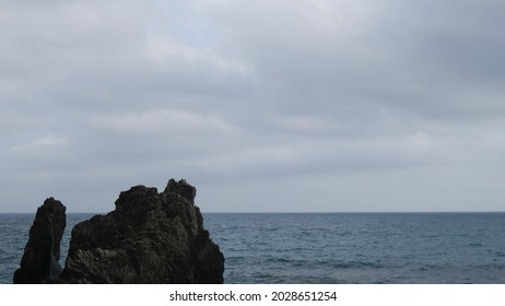 Beautiful landscape of cliff and sea or ocean. Rock on calm water, dark mood weather  - Shutterstock ID 2028651254