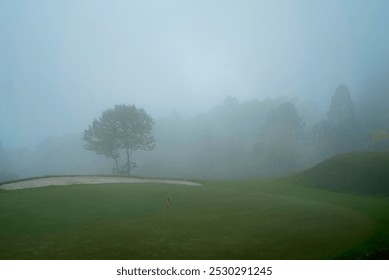 Beautiful landscape of a foggy golf course at the hill top in Kalimpong, Darjeeling. Golf Course in the mountain. Lush green grass and dark foggy cloud make this image amazing. - Powered by Shutterstock