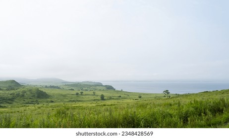 A beautiful landscape image of a sea of fog rolling through the countryside on a summer day. Fog and green hills. A low cloud over the cliffs and the sea. Selective focus. - Powered by Shutterstock