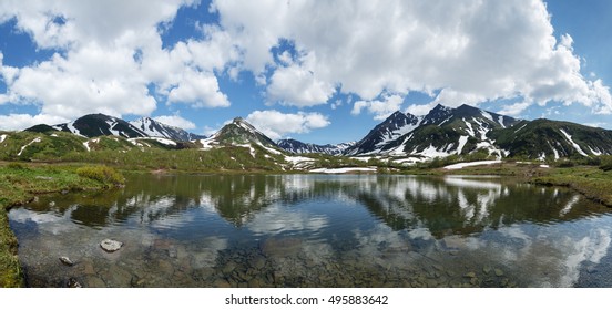 Beautiful landscape of Kamchatka Peninsula: summer panoramic view of Mountain Range Vachkazhets, stunning mountain lake and clouds in blue sky on sunny day. Russian Far East, Kamchatka Region.