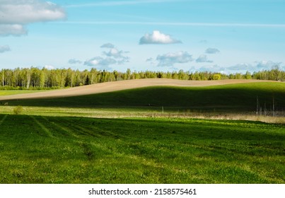 The beautiful landscape of the Latvian countryside. agricultural fields with forests. cloud shadow band on earth. contrast from dark to light