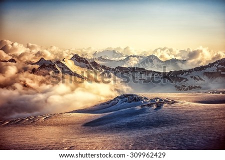 Beautiful landscape - mountain ridge of Western Caucasus in clouds at sunset or sunrise