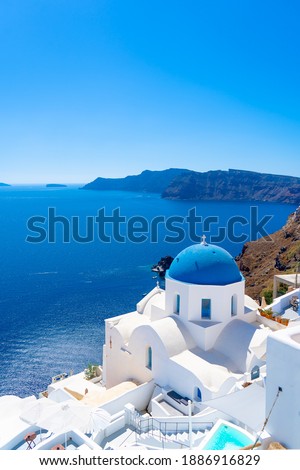 Beautiful landscape from Oia town on Santorini island, Greece. Traditional and famous houses and churches with blue domes over the Caldera, Aegean sea