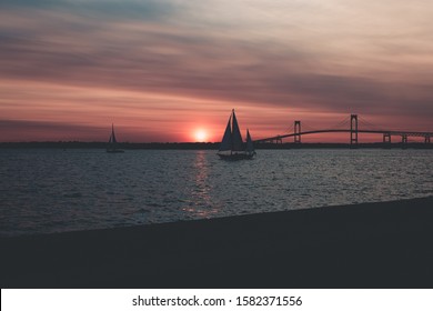 A beautiful landscape shot of sailboats in the sea near bridge under pink sky - Shutterstock ID 1582371556