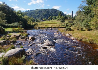 Beautiful landscape with a small river and the Round Tower at Glendalough in Wicklow Mountains