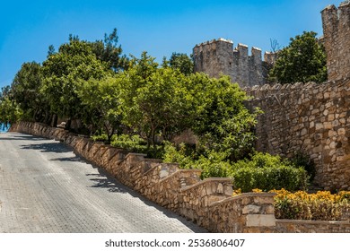 Beautiful landscape of stone fortress wall with lush greenery in historic Cesme, Turkey - Powered by Shutterstock