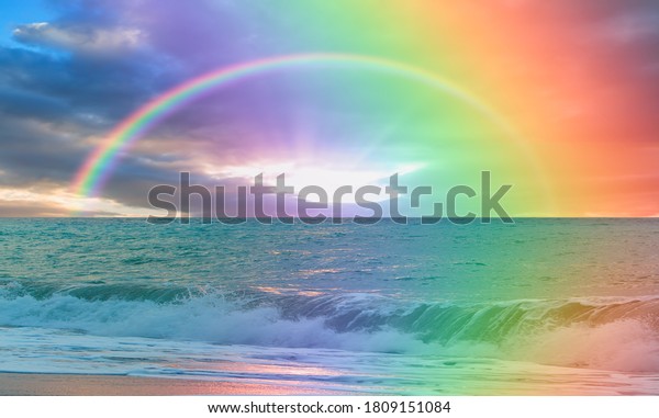 Beautiful landscape with turquoise sea, double sided rainbow in the background at amazing sunset 