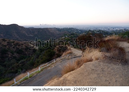 Beautiful landscape view on a road in Hollywood hills with Los Angeles on the horizon at sunrise
