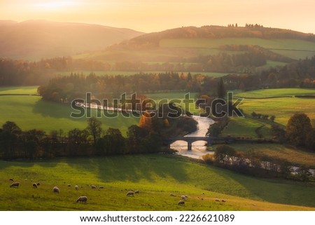 Beautiful landscape view at sunset in Autumn of rolling hills and rural countryside with Old Manor Bridge over the River Tweed near Peebles in the Scottish Borders of Scotland, UK.