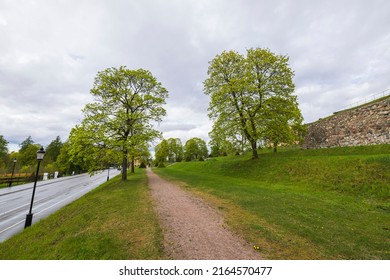 Beautiful landscape view in Uppsala city downtown with high stone wall, trees and highway. Sweden.