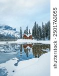 Beautiful landscape of Wooden lodge on frozen Emerald Lake in pine forest on winter at Yoho national park, BC, Canada